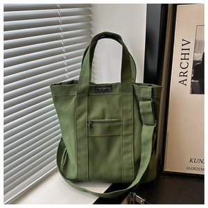 Détail du sac cabas en toile vert armée avec poche zippée et étiquette en tissu
