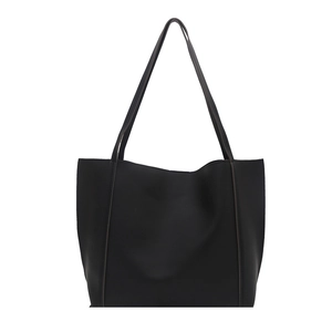 Minimalist black faux leather tote bag with vertical stitching and long shoulder straps