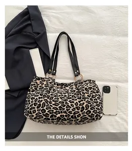 Close-up of leopard print tote bag with thick canvas fabric and black faux leather handles