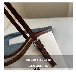 Detail of adjustable silver buckle on a pebble leather tote bag with contrast straps