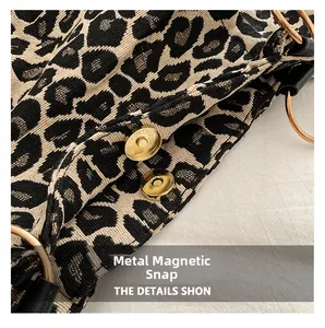 Detail of the golden magnetic clasp and woven leopard print texture on the tote bag