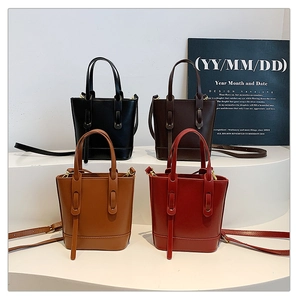 Minimalist bucket bags in black, brown, caramel, and dark red shown in tiered display