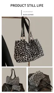 Detail view of leopard print tote bag with black faux leather strap and golden hardware