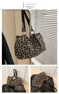 Detail of leopard print canvas tote bag with black leather straps and gold rings