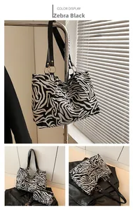 Detail of zebra print tote bag featuring black slim straps and gold ring hardware