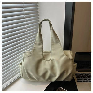 Light green pleated shoulder bag featuring wide handles and spacious side pocket