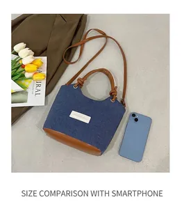 Détails du sac en jean avec lanières en cuir et smartphone pour comparer la taille