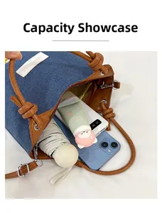 Intérieur spacieux du sac seau en jean montrant le rangement du téléphone et du parapluie