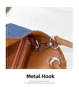 Détail du crochet métallique argenté sur le sac seau en denim et cuir marron