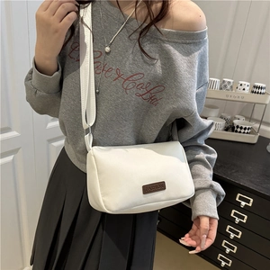 Petit sac carré blanc minimaliste avec large bandoulière et écusson en cuir mode