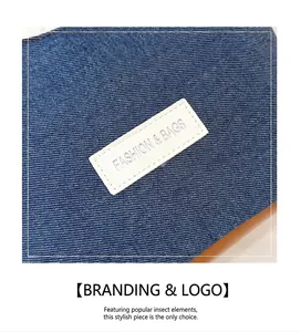 Détail du tissu denim bleu avec étiquette de logo en cuir blanc sur le sac à bandoulière