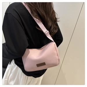 Détail de la bandoulière tissée réglable et boucle argentée sur le sac bandoulière rose