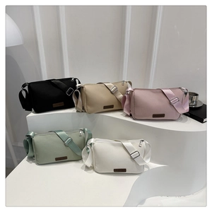 Détail de sacs bandoulière en toile imperméable en cinq couleurs avec écusson en cuir chic