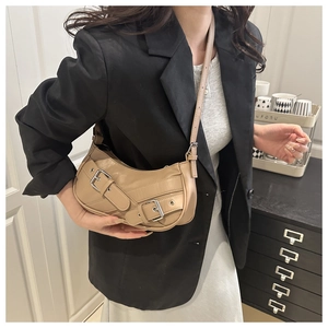 Detail view of khaki crescent shoulder bag featuring chic dual metallic buckle straps