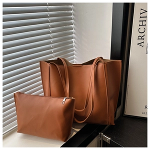 Detail of vintage brown leather tote bag set with matching zipper pouch and fine texture