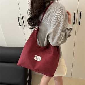 Burgundy matte suede tote bag for women with minimalist brand label in a 45-degree model view