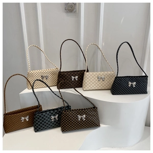 Detail of elegant underarm bags featuring monogram patterns and silver bow accents
