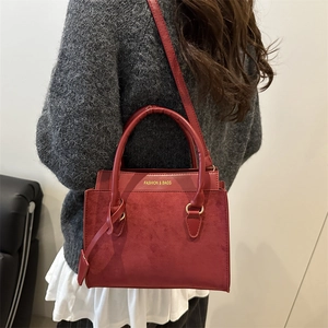 Petit sac à main bordeaux chic avec mélange de textures et détails dorés porté