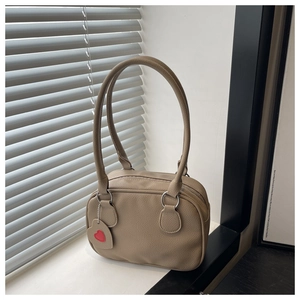 Close-up of khaki bowling handbag with lychee texture leather and a heart charm