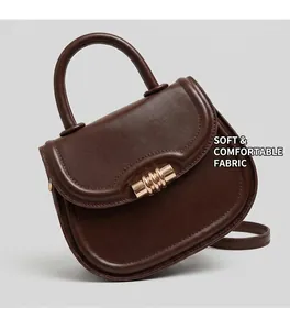 Close-up of a dark brown leather saddle bag featuring a gold ring-shaped metal buckle