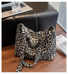 Detailed view of leopard print canvas tote bag with adjustable strap and metal hardware