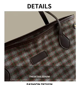 Close-up of vintage plaid fabric and premium brown leather handle with stitching detail