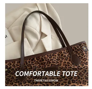 Détail du sac cabas léopard avec poignées en cuir marron et finitions en rivets métal