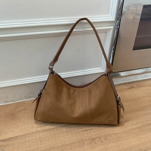 Close-up of brown suede hobo bag with leather strap and metal hardware detail