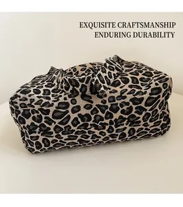 Macro shot of large leopard print jacquard tote bag with woven shoulder strap on a desk
