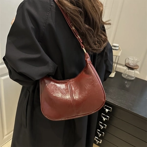 Minimalist burgundy wax leather underarm bag with semi-circle design and glossy finish