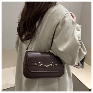 Detailed view of deep brown leather shoulder bag featuring a gold horsebit buckle