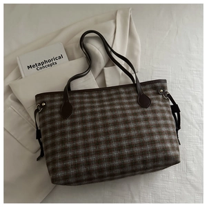 Detailed view of vintage plaid tote bag with brown leather handles and side drawstrings