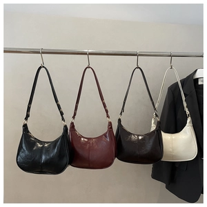 Chic dumpling bags in black, burgundy, coffee, and cream colors shown on display racks