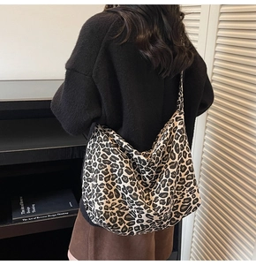 Close-up of leopard print oversized canvas hobo bag on shoulder for casual styling