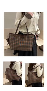 Detail of plaid tote bag with brown leather handles and adjustable side drawstrings