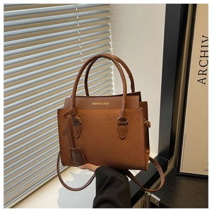 Detail of brown leather tote bag with FASHION & BAGS gold lettering and double handles