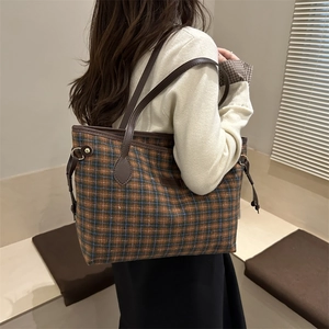 Retro plaid tote bag with brown leather straps and drawstring detail in a warm studio setting