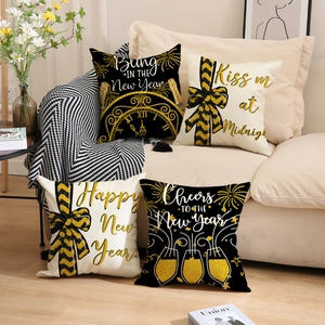 Set of four black and gold Happy New Year throw pillow covers on a cozy sofa