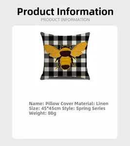 Detail of linen pillowcase with black and white plaid pattern and yellow bee illustration