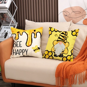 Close-up of Nordic bee and gnome decorative pillowcases on a soft fabric sofa