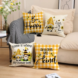 Detail of four Nordic bee and gnome theme cushion covers on a cozy beige sofa
