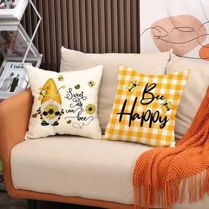 Close-up of Nordic bee and sunflower linen pillow covers on a cozy beige sofa
