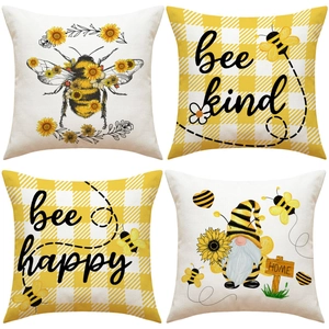 Dettaglio di quattro federe in lino con stampe di api, girasoli e gnomi da giardino