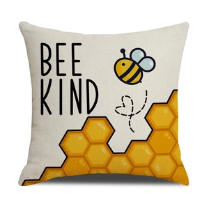Dettaglio federa in lino con stampa a nido d'ape gialla e scritta Bee Kind