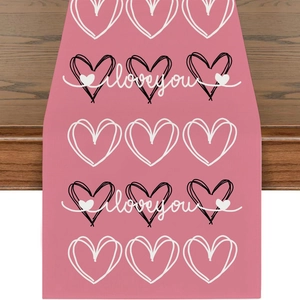 Detail eines rosa Leinentischläufers mit I Love You Herzmuster und Stofftextur