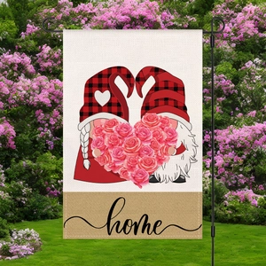 Bandera de jardín con gnomos y corazón de rosas en soporte de metal en un patio florecido