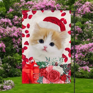 Detalle de bandera de jardín de lino con gato festivo y rosas rojas en un jardín real