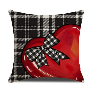 Close-up of linen pillowcase with red heart print and buffalo plaid bow decoration
