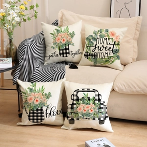 Close-up of four floral buffalo plaid linen pillow covers on a beige sofa