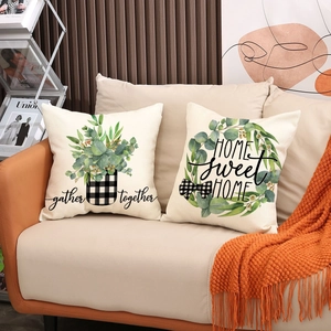 Set of two decorative plant print pillow covers with home sweet home text on sofa